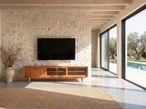 Cividale Solid Cherry Media Console under a wall-mounted screen on a pale stone wall in a poolside villa