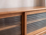 Close-up of the Cividale Solid Cherry Media Console: the two sliding reeded-glass doors and their solid cherry frames