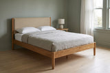 Civitella bed against a sage green wall in a Portland craftsman bedroom with a pale oak floor and a round white-oak side table