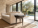 Colledara Cast Aluminum Bowl Side Table beside a linen sofa in a poolside villa