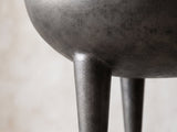 Close-up of the Colledara Cast Aluminum Bowl Side Table: a tapered cast leg growing out of the curve of the bowl