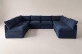 The Comiso eight-seat U-shaped sectional in navy slipcovers, seen from the open front of the U on a light studio backdrop