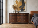 Cormons 66-Inch Dark Cherry and Burl 9-Drawer Dresser against a plaster wall in an industrial loft bedroom