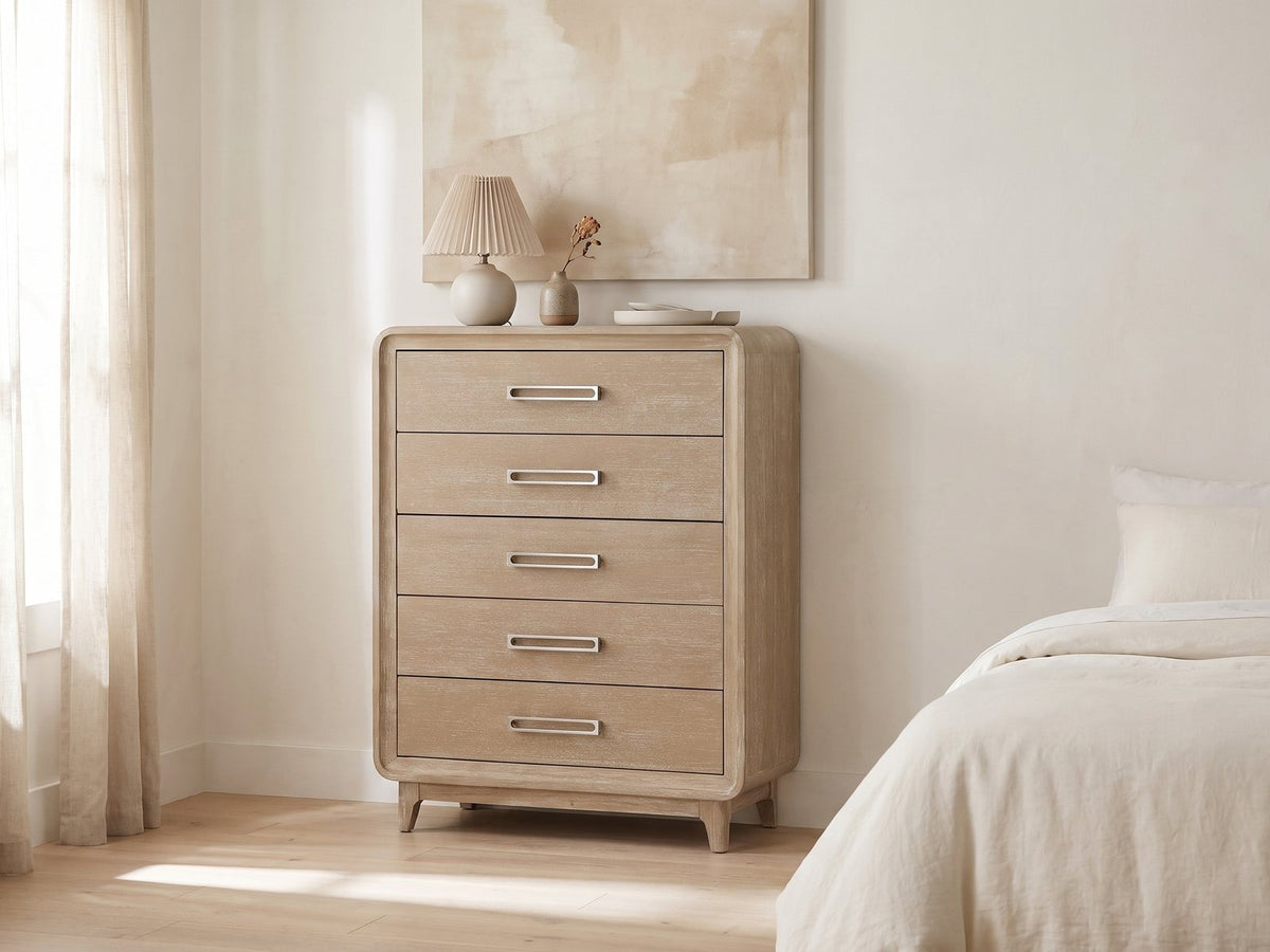 Cortina 40-Inch Natural Oak 5-Drawer Chest against a plaster wall under an abstract canvas in a bright bedroom