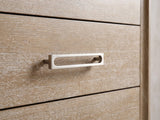 Close-up of the Cortina 40-Inch Natural Oak 5-Drawer Chest: the satin-nickel open-loop bar pull on a wire-brushed oak drawer