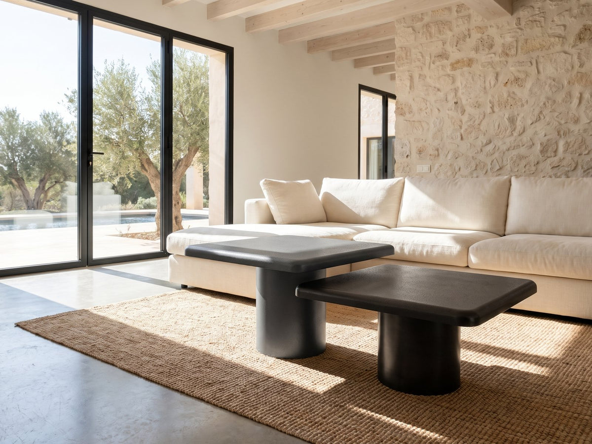 Cortona Cast Aluminum Pedestal Coffee Tables, Set of 2 on a jute rug in front of a linen sofa in a poolside villa