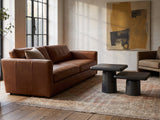 Cortona Cast Aluminum Pedestal Coffee Tables, Set of 2 on a vintage rug in front of a leather sofa in an industrial loft