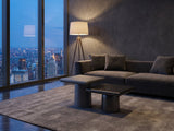 Cortona Cast Aluminum Pedestal Coffee Tables, Set of 2 on a wool rug in front of a velvet sofa in a city penthouse at blue hour