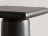 Close-up of the Cortona Cast Aluminum Pedestal Coffee Tables, Set of 2: the rounded top edge meeting the round cast aluminum column
