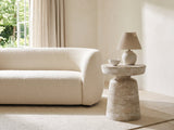 Craco Whitewashed Mango Pedestal Side Table with a lamp and a ceramic bowl beside a cream boucle sofa in a bright plaster room