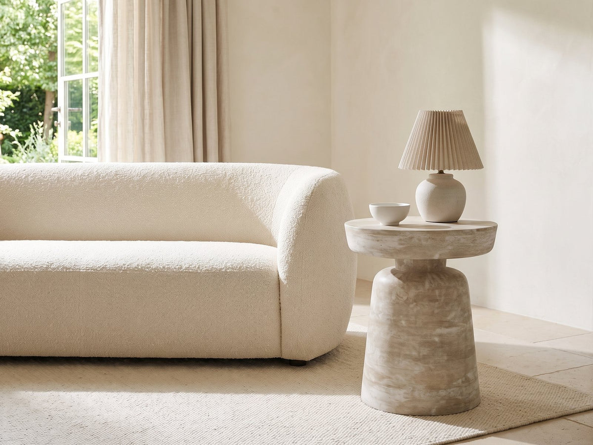 Craco Whitewashed Mango Pedestal Side Table with a lamp and a ceramic bowl beside a cream boucle sofa in a bright plaster room