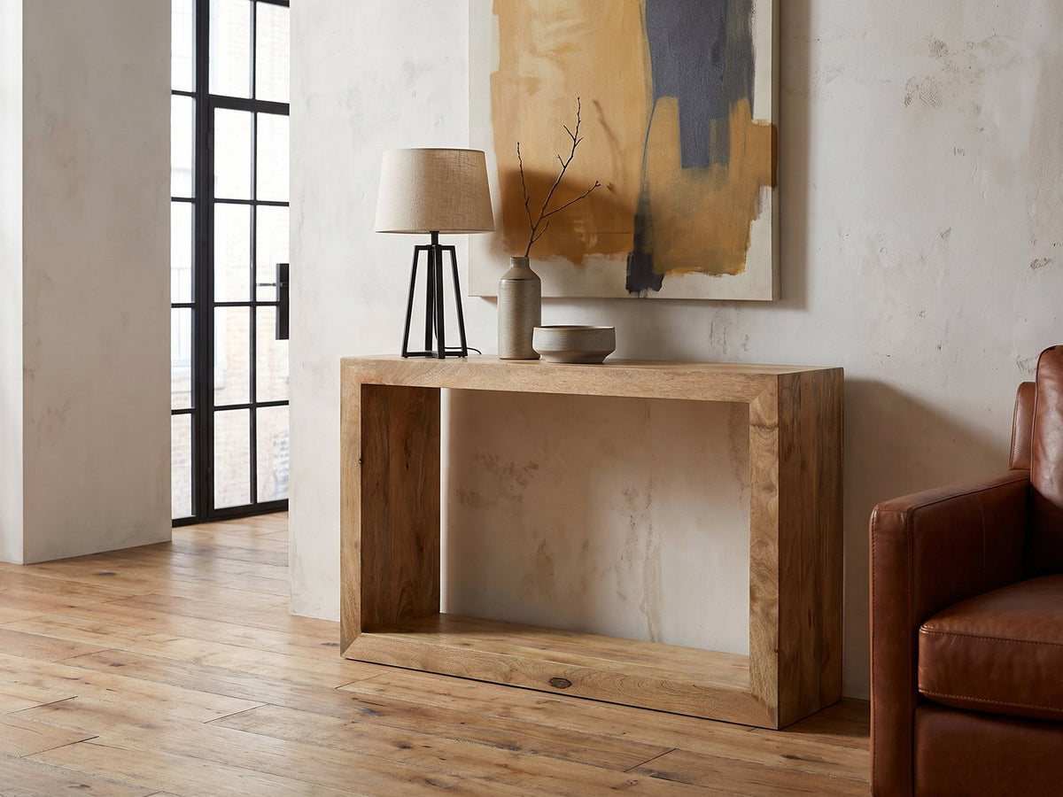 Crispiano Mango Wood Open Frame Console Table against a plaster wall in an industrial loft