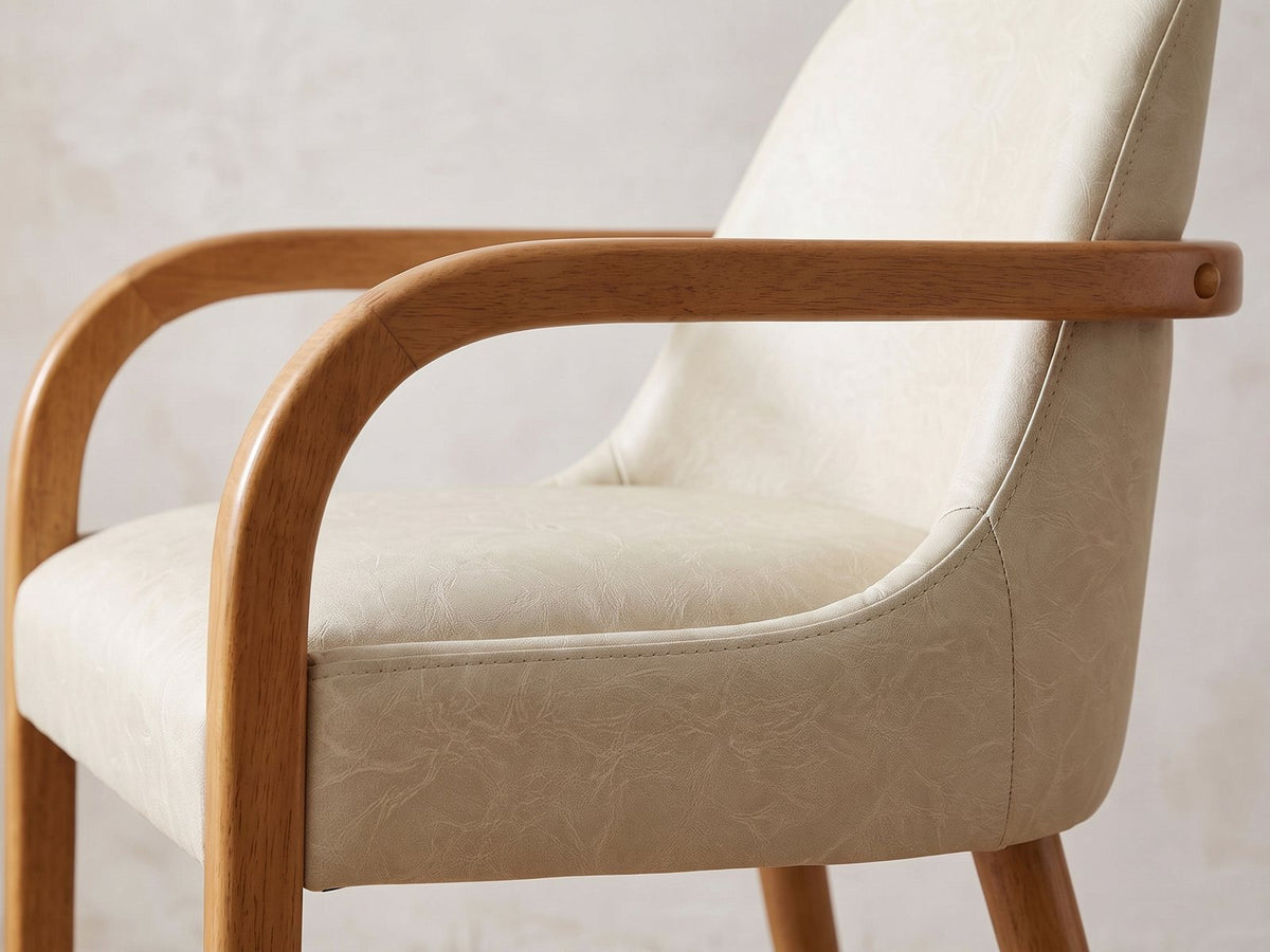 Close-up of the Cropani 69-Inch Rectangular Fluted Dining Set with 4 Arm Chairs: the bent-wood arm and curved khaki faux leather back of one arm chair