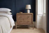 Cuglieri latte elm nightstand against a deep navy wall in a Brooklyn brownstone bedroom with a herringbone floor and a white shuttered window