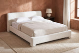 Cupello platform bed against a terracotta clay plaster wall in a Santa Fe bedroom with a limestone floor and a wool rug