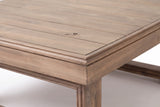 Close-up of the Custonaci table: acacia planks with natural grain and a knot, the border frame and the moulded apron corner