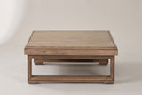 The Custonaci coffee table seen from the front: the deep apron over one closed sled frame, the second sled frame behind