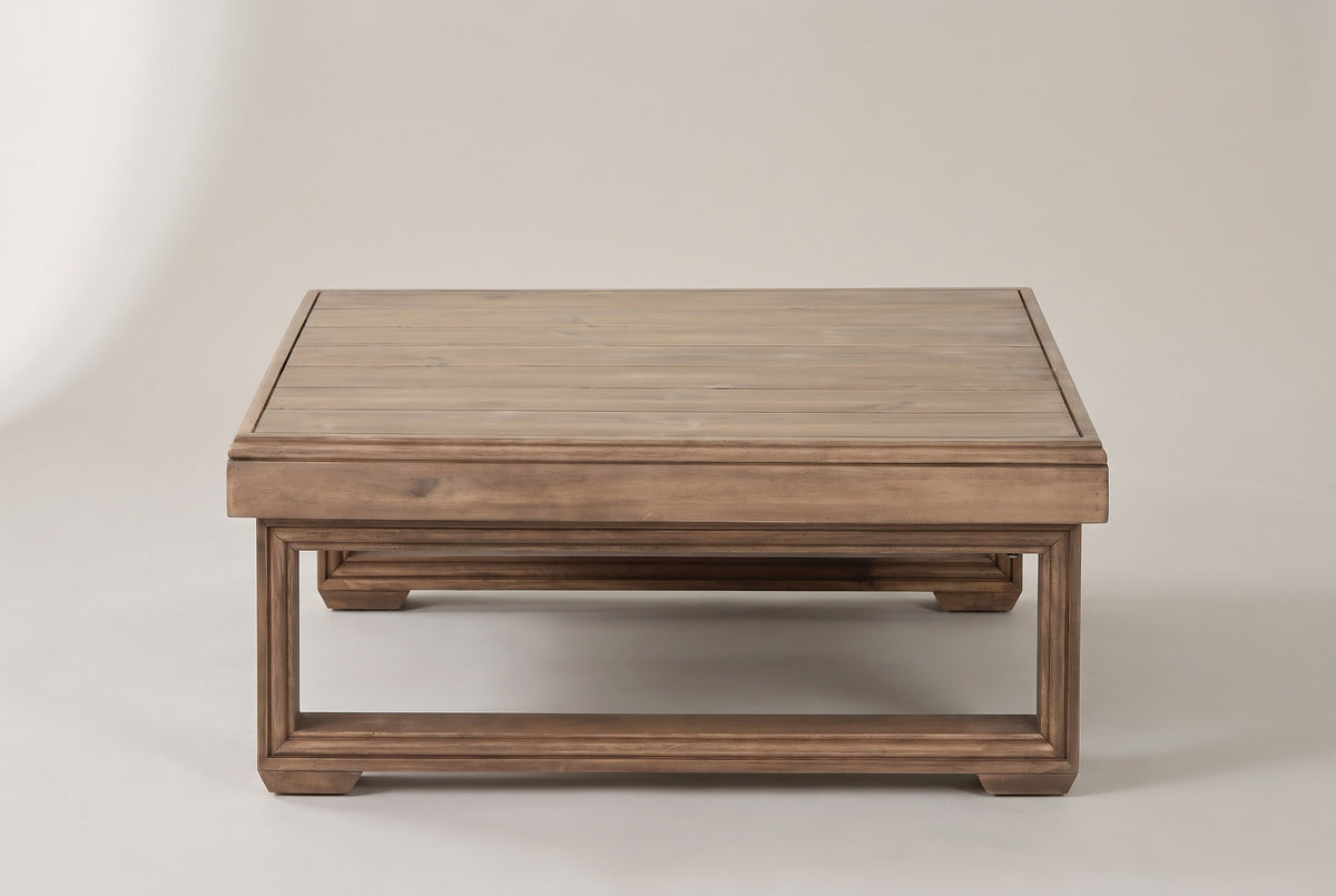 The Custonaci coffee table seen from the front: the deep apron over one closed sled frame, the second sled frame behind
