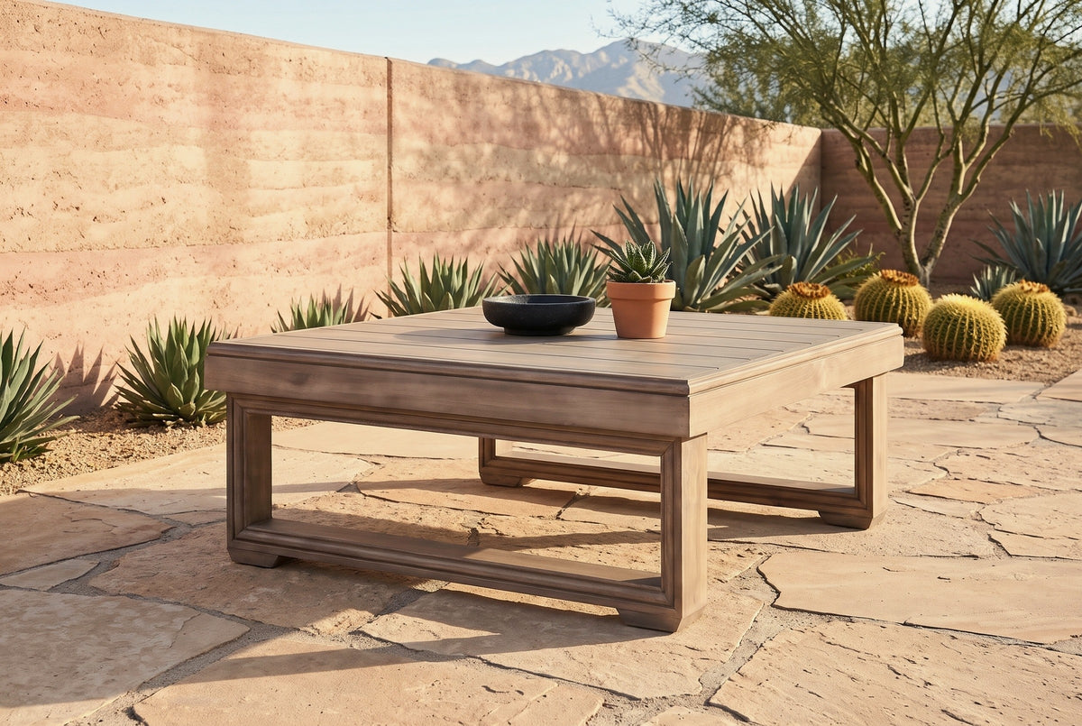 Custonaci acacia coffee table on buff flagstones at a desert house near Tucson, a rammed-earth wall, agaves and barrel cactus behind (bowl and plant not included)