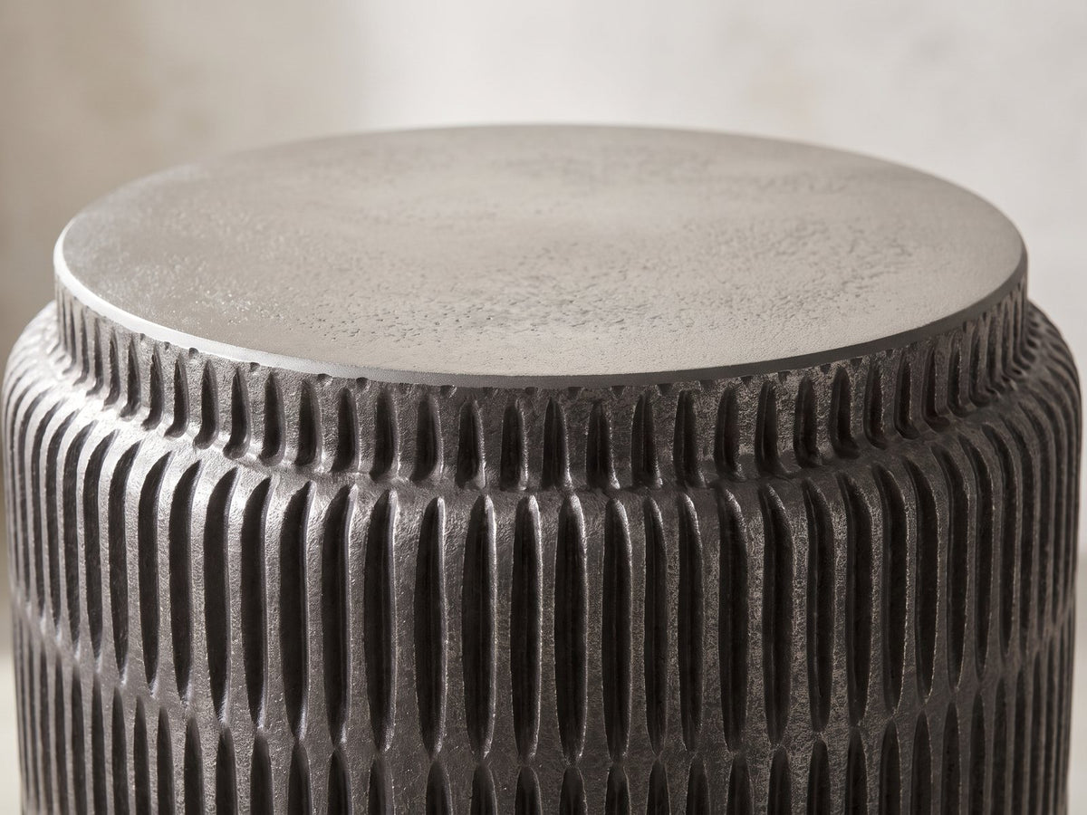 Close-up of the Cutigliano Cast Aluminum Carved Cylinder Side Table: the pewter top disc on the carved graphite collar
