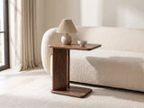 Cutrofiano Walnut Veneer C-Shaped Side Table with a lamp and a ceramic bowl beside a cream boucle sofa in a bright plaster room