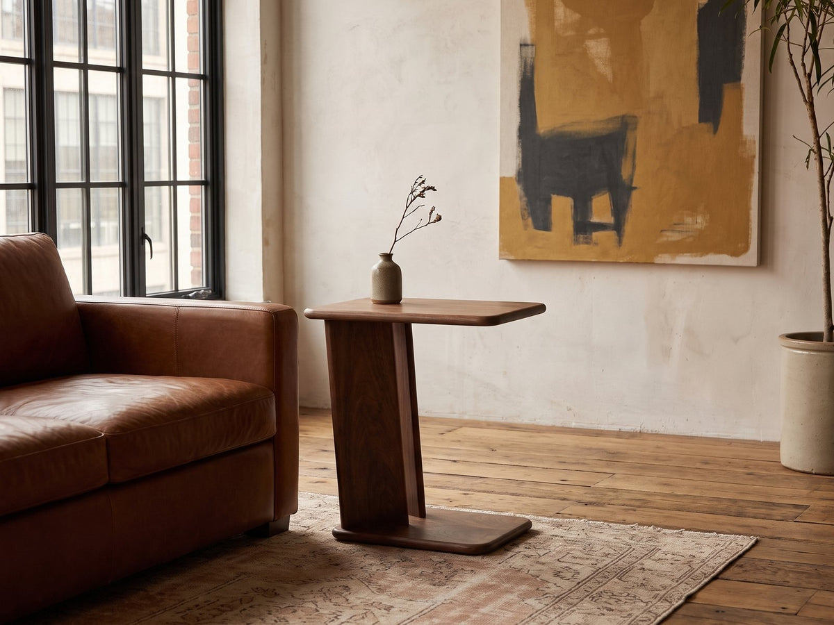 Cutrofiano Walnut Veneer C-Shaped Side Table beside a leather sofa in an industrial loft