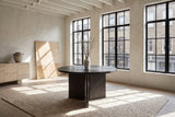 Davoli 54-Inch Round Ebony Oak Veneer Pedestal Dining Table in a city loft