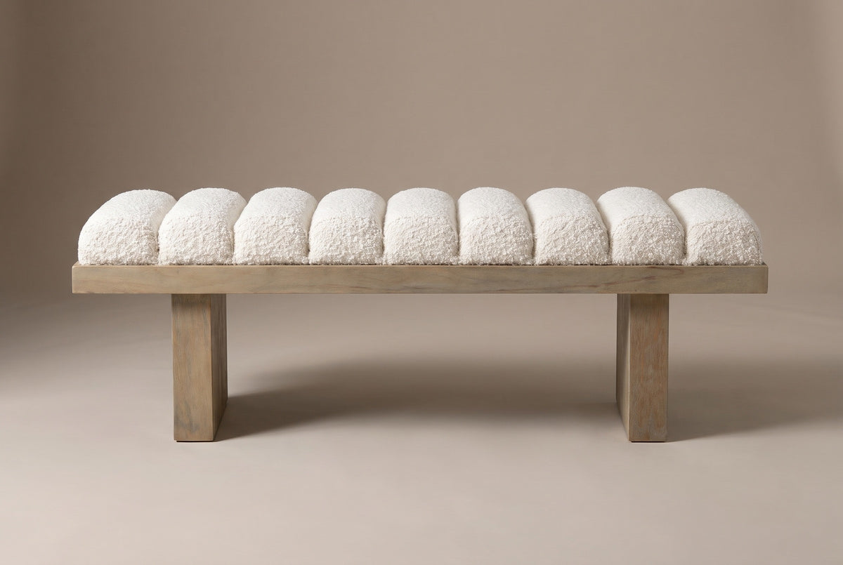 The Deruta bench in ivory white boucle, front view on a light studio backdrop: nine channels, a wood frame and two slab legs