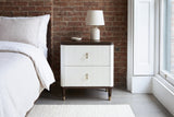 Desulo white fluted nightstand against an exposed red-brown brick wall in a Brooklyn brownstone bedroom with a tall sash window