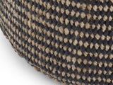 Close-up of the Dolceacqua Natural Braided Jute Round Pouf: the black and natural jute weave of the side down to the bottom edge