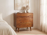 Dolo 28-Inch Chestnut Solid Mango 3-Drawer Chest against a plaster wall under an abstract canvas in a bright bedroom