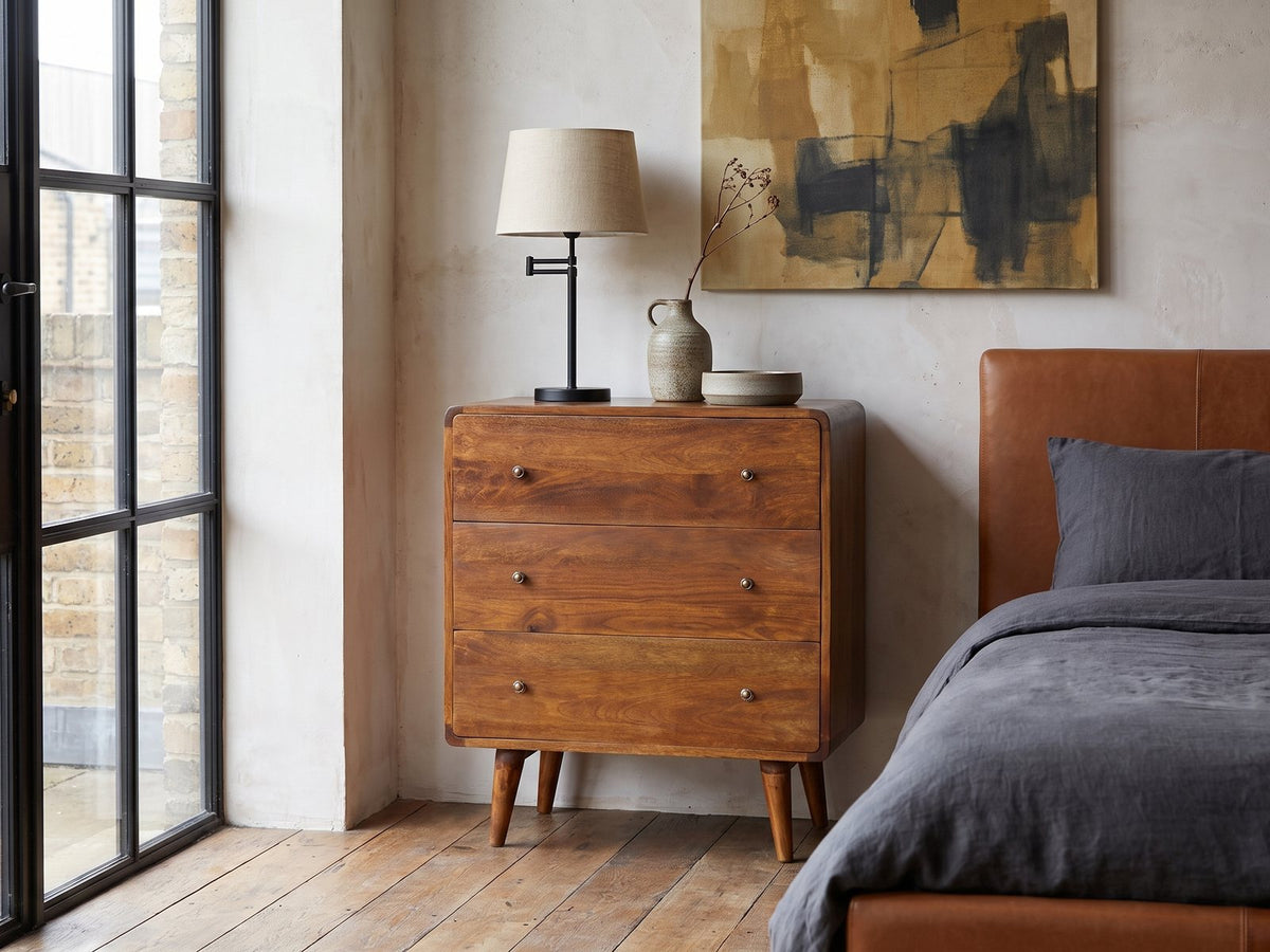 Dolo 28-Inch Chestnut Solid Mango 3-Drawer Chest against a plaster wall in an industrial loft bedroom