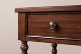 The drawer of the Dorgali nightstand up close: a flat veneer front with a slim moulded rim and an antique brushed metal knob, beneath the thin top