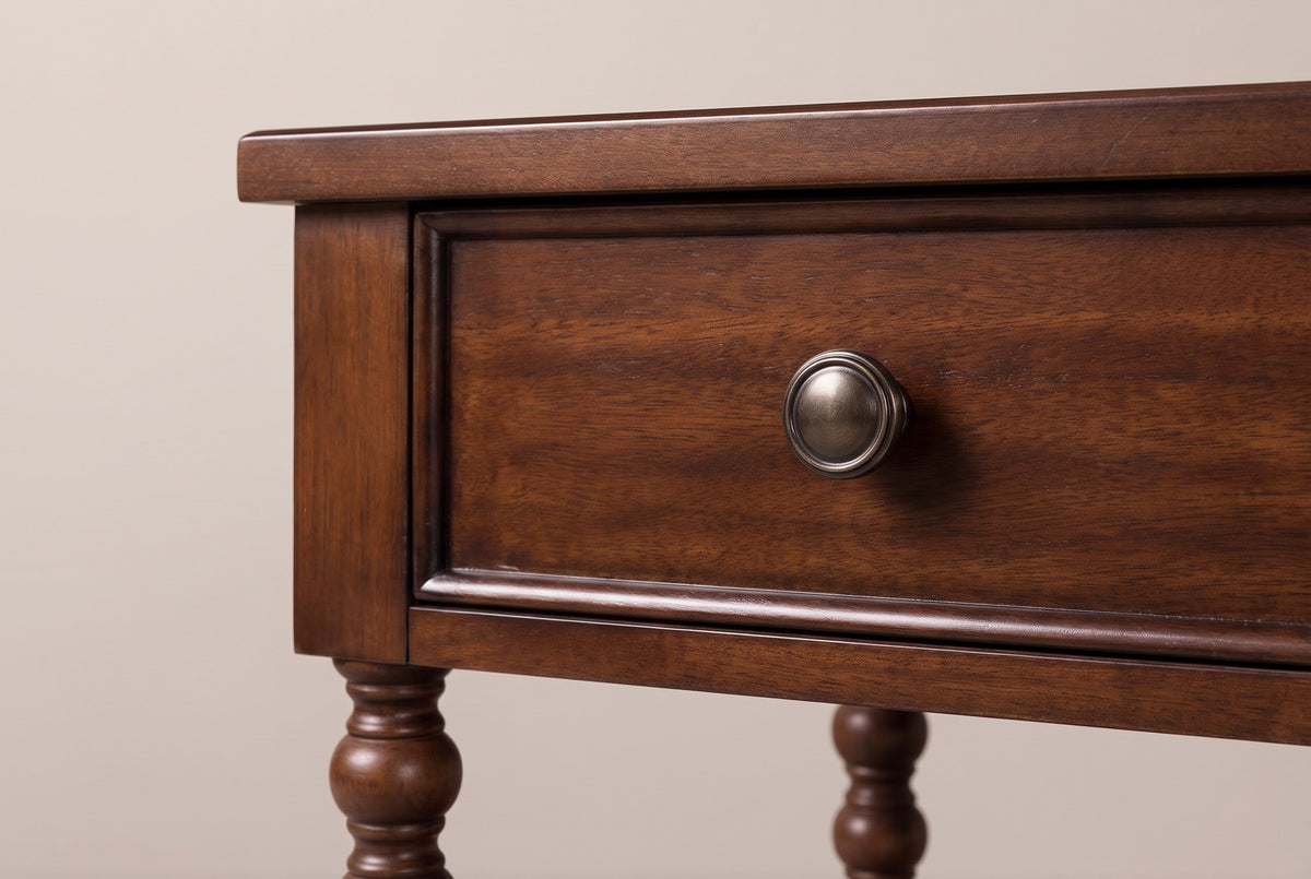The drawer of the Dorgali nightstand up close: a flat veneer front with a slim moulded rim and an antique brushed metal knob, beneath the thin top