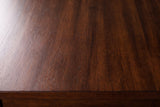 Close-up of the Dorgali nightstand top: Morocco Brown wood veneer with a fine striped figure and a soft sheen, with the square edge of the top below