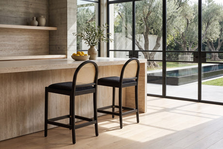 Drapia 26.5-Inch Cane-Back Ebony Oak Counter Stool, Black Boucle (Set of 2) in a sunlit villa dining room