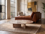 Elba Rosa Marble Coffee Table on a vintage rug in front of a leather sofa in an industrial loft