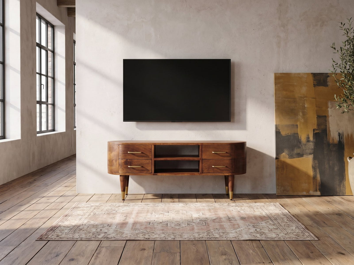 Erice Curved Mango Media Console under a wall-mounted screen in an industrial loft
