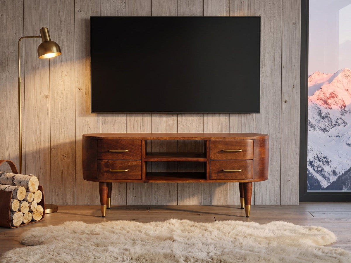 Erice Curved Mango Media Console under a wall-mounted screen in an alpine chalet at dusk