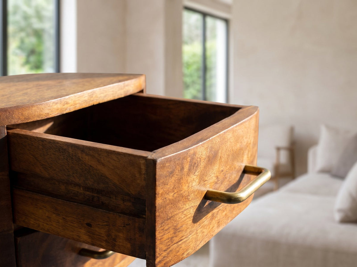 Close-up of the Erice Curved Mango Media Console: an open mango drawer with its brass pull