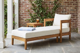 Favignana acacia chaise in a Charleston garden loggia with an old red-brick wall, star jasmine and a bluestone floor (side table not included)