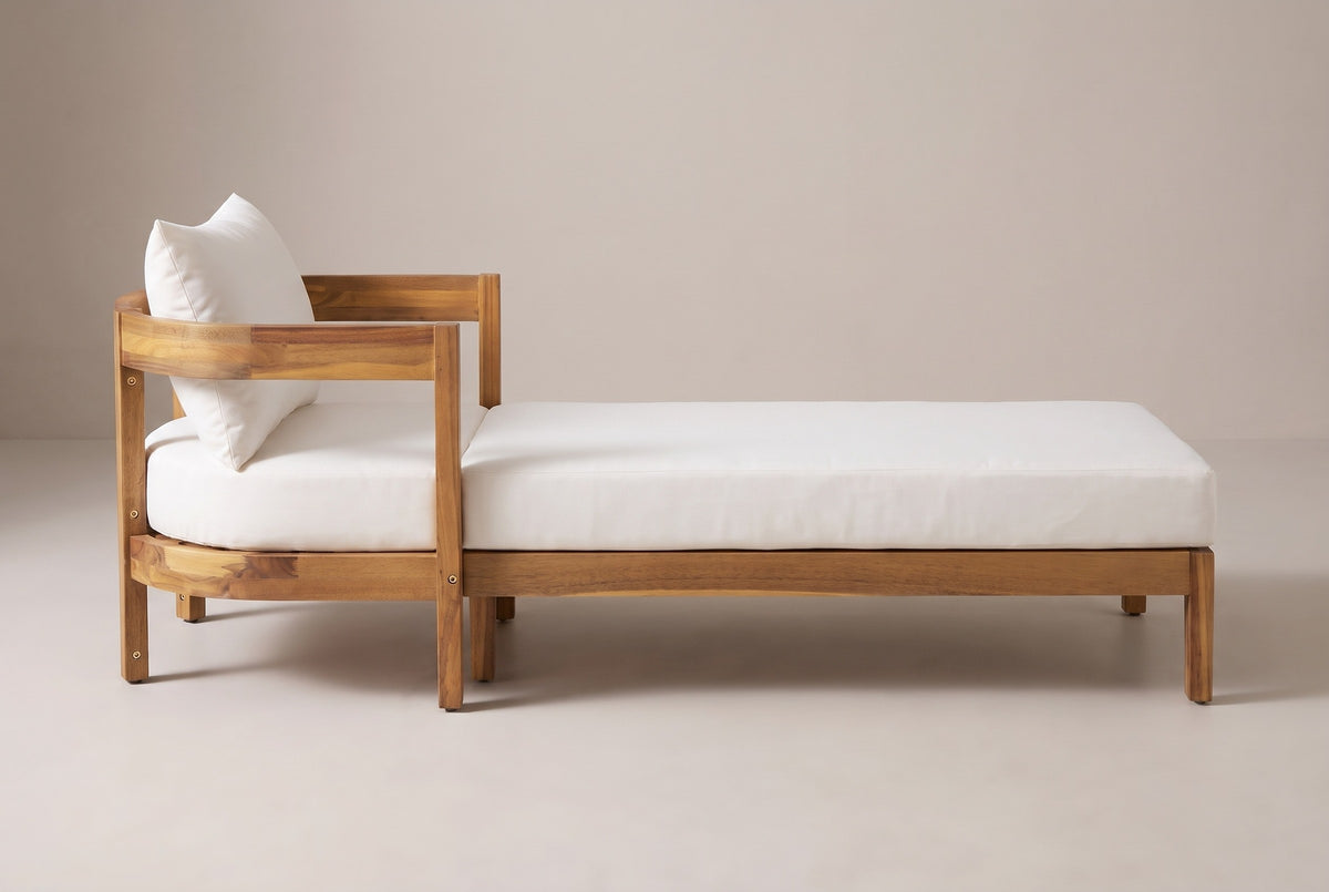 The Favignana chaise lounge seen from the side: the curved head end on the left and the long low frame on square legs