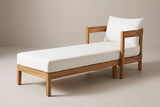 The Favignana acacia chaise lounge with ivory cushions, three-quarter view from the foot end on a light studio backdrop