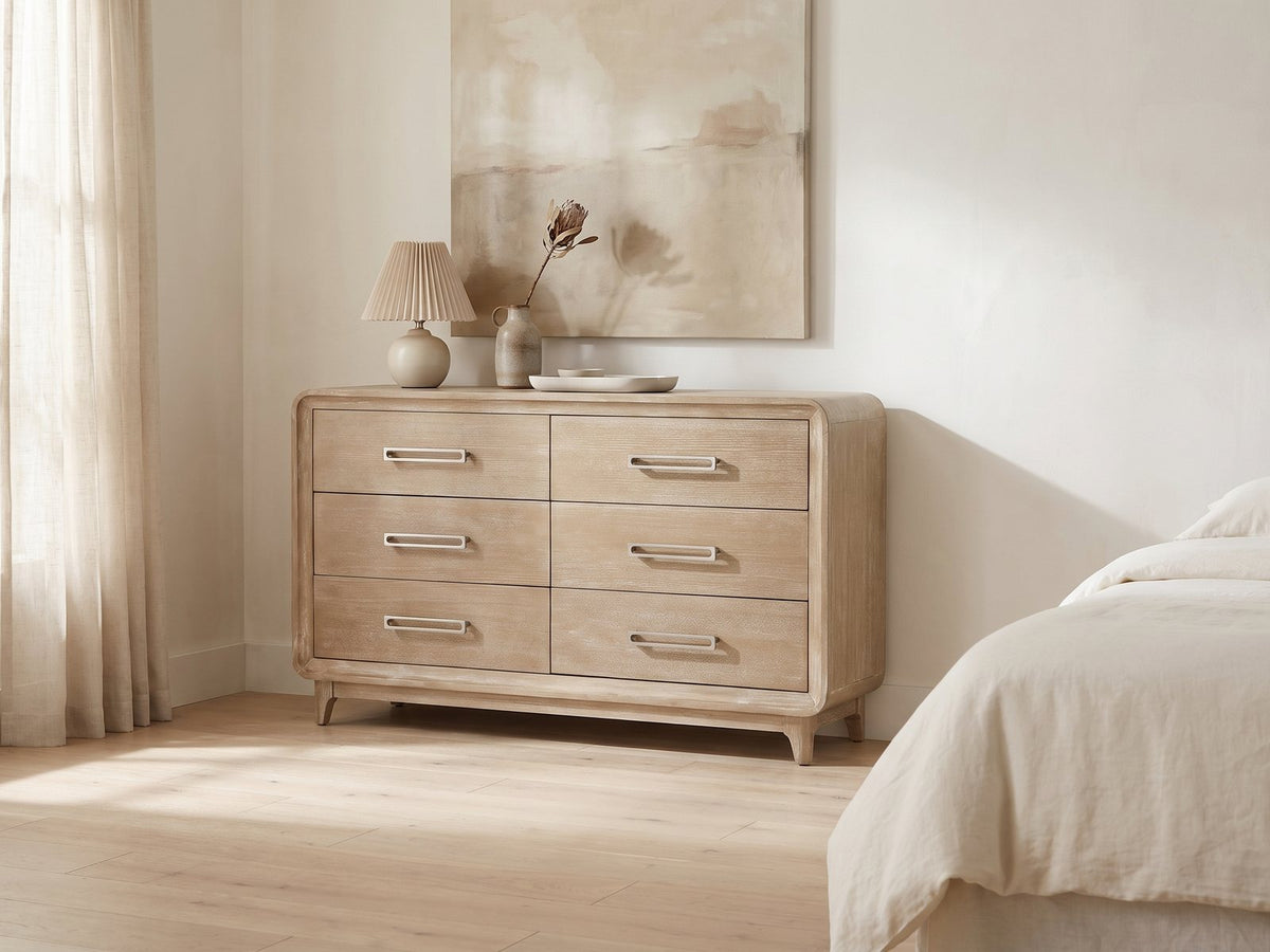 Feltre 62-Inch Natural Cerused Oak 6-Drawer Dresser against a plaster wall under an abstract canvas in a bright bedroom
