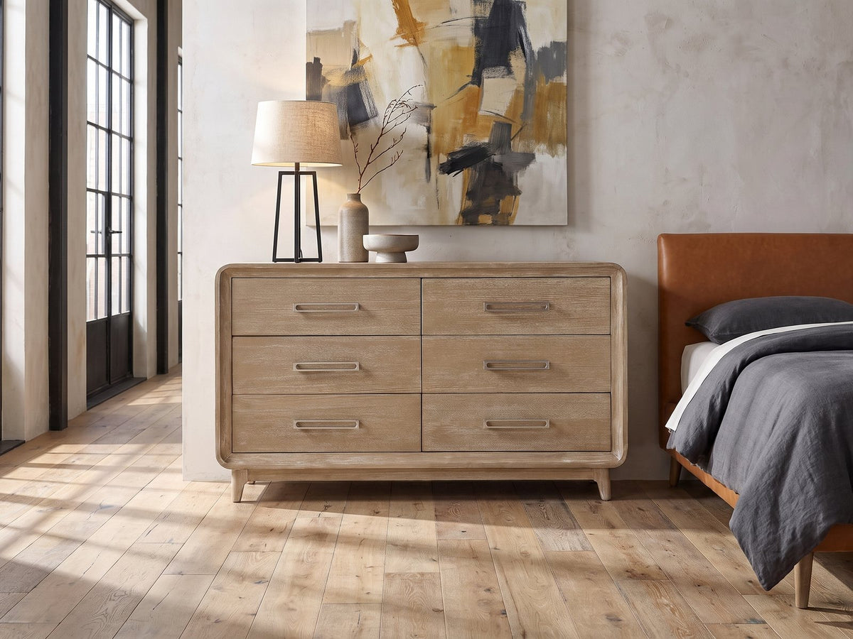 Feltre 62-Inch Natural Cerused Oak 6-Drawer Dresser against a plaster wall in an industrial loft bedroom