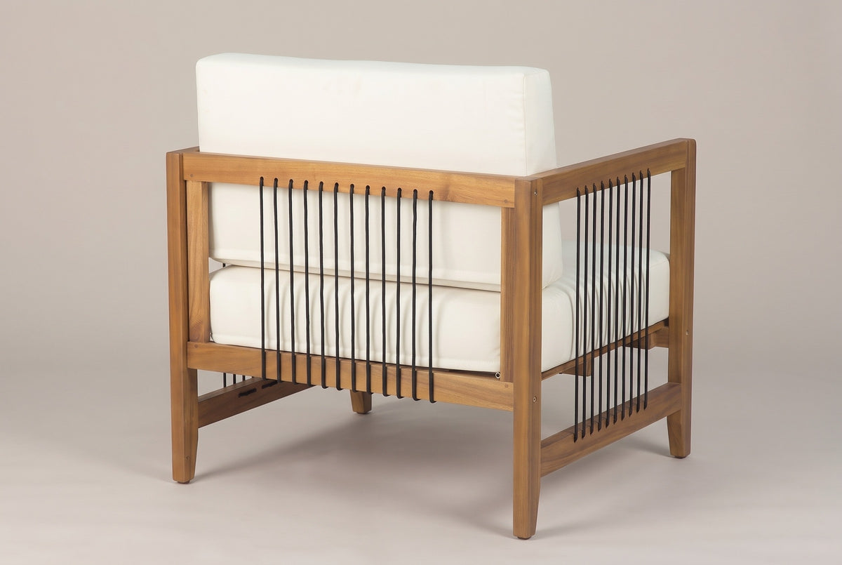 A Ficarra armchair seen from behind: the acacia back frame with a row of black cords, the ivory back cushion above it