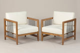 The two Ficarra acacia armchairs with ivory cushions and black rope side panels, three-quarter view on a light studio backdrop