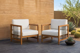 Two Ficarra acacia armchairs on dark slate pavers in front of an ochre rammed-earth wall, agaves and barrel cacti beside them (planter not included)