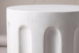 Close-up of the smooth white concrete at the top edge of the Ficuzza side table, with the arched tops of two flutes