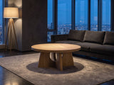 Fiesole Cerused Oak Veneer Round Pedestal Coffee Table on a wool rug in front of a velvet sofa in a city penthouse at blue hour